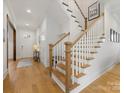 Bright entryway featuring hardwood floors, a staircase with wooden railings, and white trim at 2626 Palm Ave, Charlotte, NC 28205