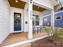 Inviting covered front porch with seating, stylish door, and wooden ceiling detail at 2626 Palm Ave, Charlotte, NC 28205