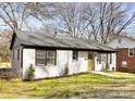 Quaint home featuring a white brick exterior and a walkway leading to the green front door at 4308 Welling Ave, Charlotte, NC 28208