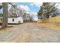 Expansive backyard with a gravel driveway and a newly installed wood fence, offering ample space at 813 Carrid Dr, Gastonia, NC 28052