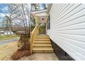 Inviting entryway featuring wooden stairs and railing leading to a covered porch and freshly painted siding at 813 Carrid Dr, Gastonia, NC 28052