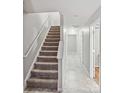 Inviting hallway with stairs leading to upper levels, featuring neutral tones and ample lighting at 10094 Treeside Ln, Matthews, NC 28105