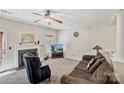 Cozy living area featuring a fireplace, plush carpeting, and a ceiling fan at 10094 Treeside Ln, Matthews, NC 28105