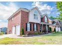 Brick home with a two-car garage, well-manicured lawn, and a classic suburban appeal at 10836 Clark St, Davidson, NC 28036