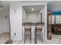 A bar area with two stools, with white walls and wood-look flooring at 11014 Fox Mill Ln, Charlotte, NC 28277