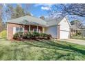 Charming single-story brick home featuring an attached two-car garage, well-maintained yard at 1107 Franklin Thomas Pl, Charlotte, NC 28214