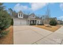 Charming home featuring a two-car garage, beautifully landscaped front yard, and inviting covered porch at 14621 Brannock Hills Dr, Charlotte, NC 28278