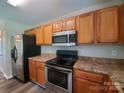 Well-equipped kitchen with stainless steel appliances, wooden cabinetry and dark countertop at 2108 Cranberry Woods Ct, Charlotte, NC 28208