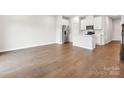 Open-concept living area with wood flooring and a view of the kitchen and stairs at 2130 Old Rivers Rd, Concord, NC 28027