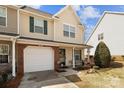 Inviting townhouse featuring a one-car garage, charming front porch, and well-manicured lawn at 2592 Brackley Nw Pl, Concord, NC 28027