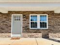 Inviting front exterior with stone accents, a light gray front door, and a 