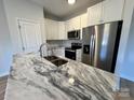 Modern kitchen with white cabinets, stainless steel appliances, and a marble countertop island at 705 Clara St, Gastonia, NC 28054