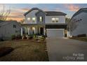 Elegant two-story home featuring a well-lit exterior, manicured landscaping, and a spacious driveway at 7200 Irongate Dr, Indian Land, SC 29707