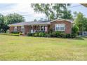 Charming brick ranch home with a well-manicured lawn, mature trees, and an inviting front porch at 7271 Hallman Mill Rd, Vale, NC 28168