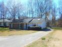 A well-maintained house on a sunny day, with a paved driveway and front yard featuring mature trees at 8319 Golf Ridge Dr, Charlotte, NC 28277