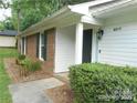 Inviting front entrance with a well-kept landscape, brick accents, and a partially covered entryway at 8319 Golf Ridge Dr, Charlotte, NC 28277