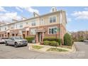 View of multiple townhomes with brick facade, well-maintained landscaping, and copper roof accents at 8410 Scotney Bluff Ave, Charlotte, NC 28273