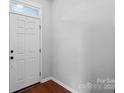 Clean entryway featuring a white door with a window above and dark hardwood floors at 1009 Rocky Meadows Ln, Concord, NC 28025