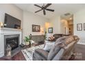 Comfortable living room with a fireplace, mounted TV, and stylish decor that includes a decorative cabinet at 116 Paradise Hills Cir, Mooresville, NC 28115