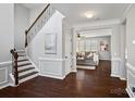 Elegant entryway featuring a staircase with wrought iron railing and an adjacent living room at 1161 Woodwinds Dr, Waxhaw, NC 28173