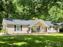 Inviting single-story home featuring a cozy front porch with rocking chairs and professional landscaping, enhanced by lush greenery at 1937 Hickory Dr, Lancaster, SC 29720