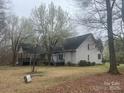 A traditional home with gray vinyl siding and a rear deck, nestled among mature trees and a spacious backyard at 2025 Sojourn Rd, Marshville, NC 28103