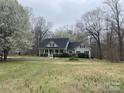 A lovely home featuring gray siding, a black roof, and surrounded by trees, offering privacy and curb appeal at 2025 Sojourn Rd, Marshville, NC 28103