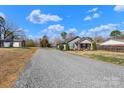 A long gravel driveway leads to a detached garage next to the home at 2211 Waverly St, Albemarle, NC 28001