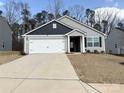 Well-maintained home featuring an attached garage, tidy landscaping, and gray siding at 3122 Maple Ridge Dr, Gastonia, NC 28052