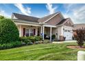 Attractive home with a welcoming porch, a one car garage, and beautiful garden beds at 313 Garner Dr, Salisbury, NC 28146