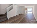 Open-concept living room featuring hardwood flooring, staircase, and natural light from sliding doors at 3209 Blythe Ridge Ct, Charlotte, NC 28213