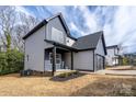 Side view of a modern two-story home featuring blue and gray siding and a covered porch at 324 Cabarrus W Ave, Concord, NC 28025