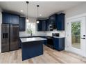 Modern kitchen with navy blue cabinetry, stainless steel appliances, and granite countertops at 324 Cabarrus W Ave, Concord, NC 28025