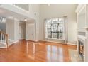 Spacious living room with hardwood floors, staircase, fireplace, and a large window at 3320 Tulip Tree Ln, Charlotte, NC 28273