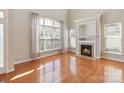 Bright living room features a fireplace, hardwood floors, and large windows for natural light at 3320 Tulip Tree Ln, Charlotte, NC 28273