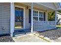 A cozy front porch with a bench, black mulch and a dark front door at 3345 Hunting Wood Ct, Gastonia, NC 28052