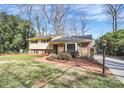 Inviting two-story home with yellow siding and brick accents, complemented by mature landscaping and a walkway at 3615 Henshaw Rd, Charlotte, NC 28209