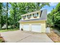 Spacious two-car garage with upper level and matching yellow siding, and an extra side entrance at 3615 Henshaw Rd, Charlotte, NC 28209