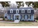 Charming two-story home featuring blue siding, black shutters, and manicured landscaping at 4000 Bridgewood Ln, Charlotte, NC 28226