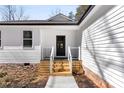 Close up of the entryway featuring a black front door, wood stairs, and white railings at 433 Cornerstone Dr, Taylorsville, NC 28681