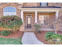 Inviting front porch leads to a charming entryway with decorative glass door at 485 Sutro Forest Nw Dr, Concord, NC 28027