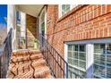 Brick front porch with black iron railing and steps leading up to a front door framed by classic white columns at 663 Sixth Baxter Xing, Fort Mill, SC 29708