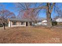 Single-story home featuring brick facade, wooden shutters, and a big front yard with a few trees at 8009 Idlewild Rd, Indian Trail, NC 28079