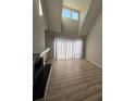 Bright and airy living room featuring wood floors, a fireplace, and a large window for natural light at 9037 J M Keynes Dr, Charlotte, NC 28262