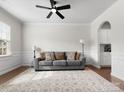 Cozy living room featuring a ceiling fan, gray sofa, large rug, and wainscoting at 925 Deep River Way, Waxhaw, NC 28173