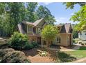 Traditional home exterior with stone and siding, a neatly landscaped yard and pathway to the front door, and mature trees at 109 Hawksnest Ln, Mooresville, NC 28117