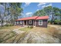 Inviting home with a striking red roof, complemented by brown siding and well-maintained landscaping at 127 Barry Oak Rd, Statesville, NC 28625