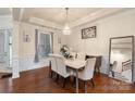 Elegant dining room featuring a modern chandelier, a marble dining table set, and hardwood flooring at 12726 Rusty Blackbird Way, Charlotte, NC 28278