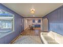 Bright living room featuring wood floors, blue walls, and an open floor plan leading to the dining area at 1605 5Th St, Statesville, NC 28625