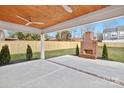 Relaxing covered patio features a brick fireplace, ceiling fan, and view of fenced yard at 1817 S Mint St, Charlotte, NC 28203